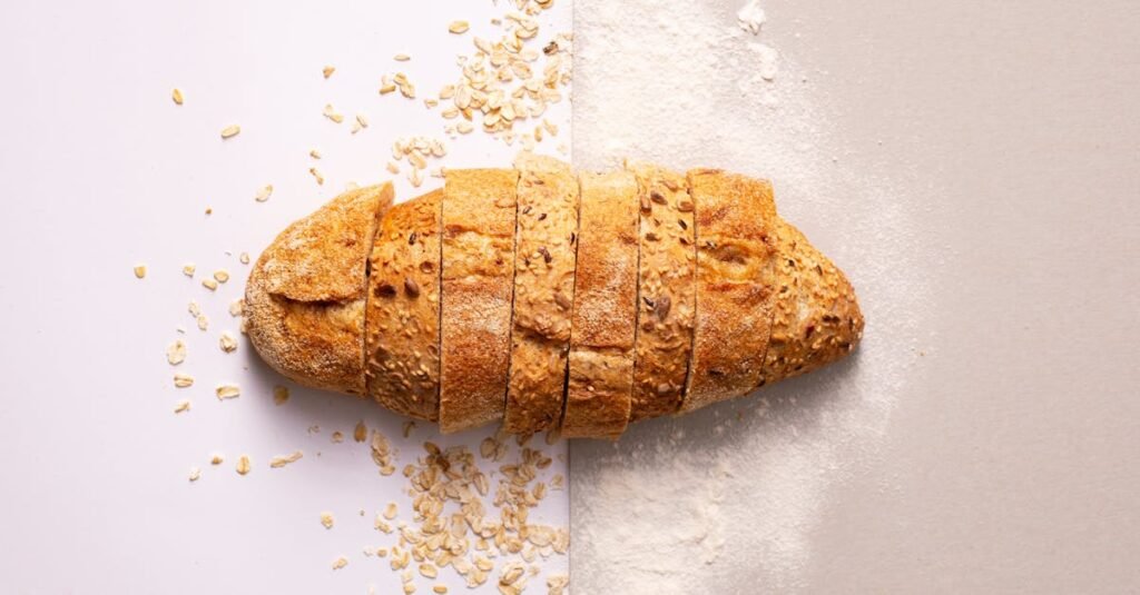Freshly sliced whole grain bread with oats and flour provides a rustic and nutritious appeal.